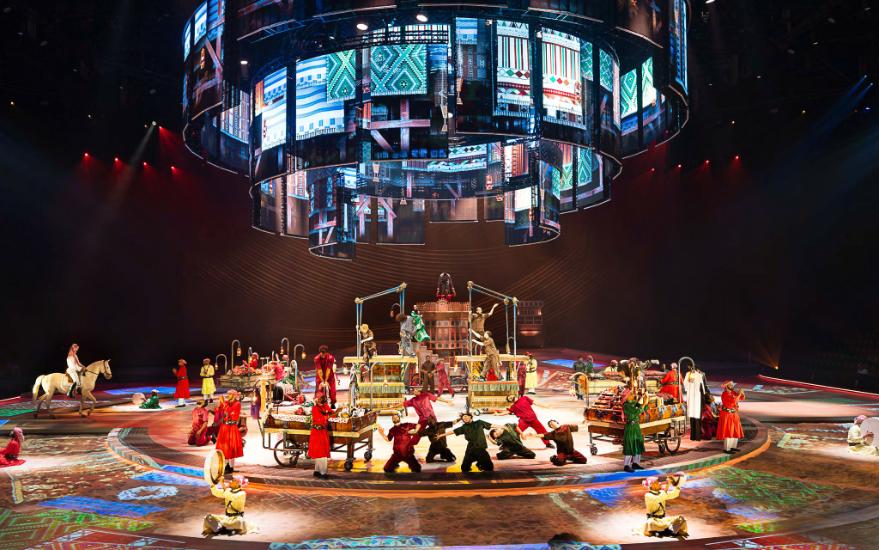 Architectural-scale set wrapped in large-format light and projection.