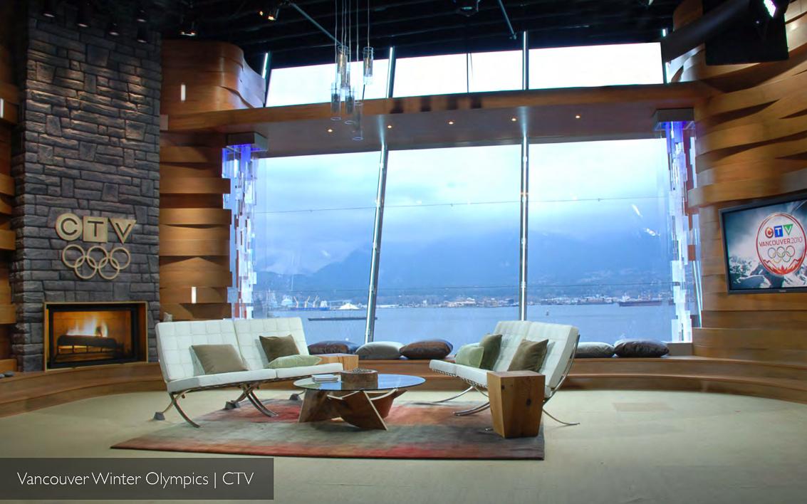 CTV Vancouver 2010 fireside lounge area: stone hearth with CTV-Olympic emblem, white leather chairs and a wraparound window onto the North Shore mountains.