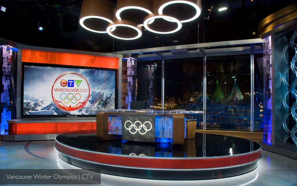 CTV Vancouver 2010 night shot of the anchor desk under the ring chandelier, with Vancouver harbour lights and the Canada Place sails glowing through the window.