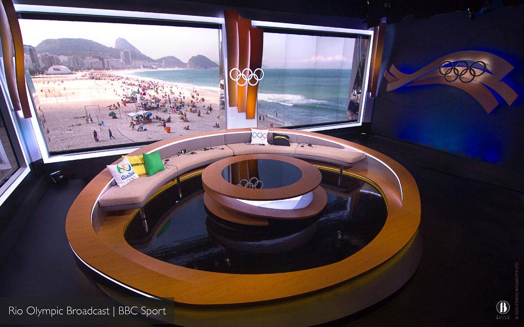 BBC Sport's Rio 2016 Olympic broadcast set — a curved sofa and circular desk framed by the Olympic rings and a window onto Copacabana Beach. Production design by Patrick Larsen.