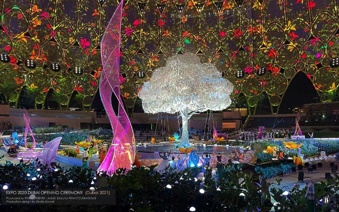 The plaza dressed as a jewelled garden — a crystal tree at the centre, the dome above painted in projected flora. Production design by Studio Bound.