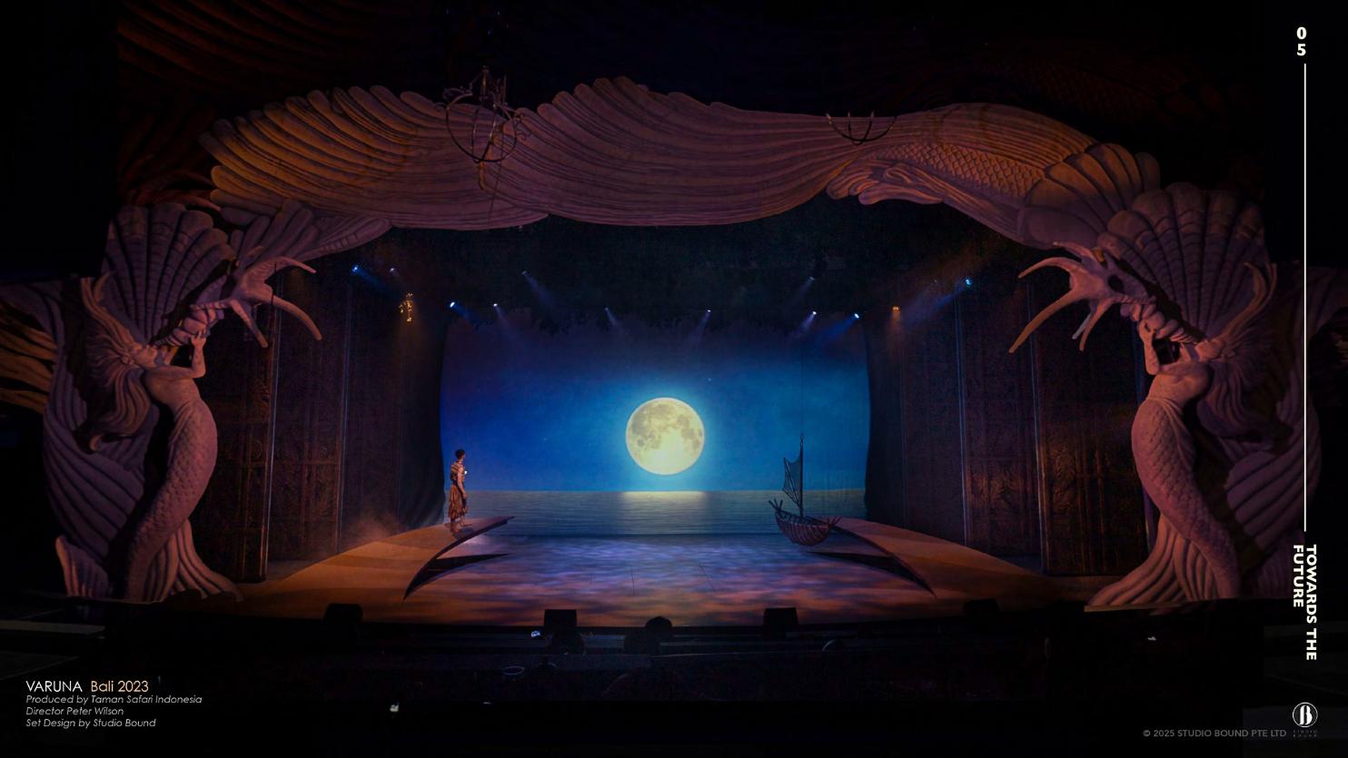 Varuna stage at Bali Safari Park — a lone performer stands before a luminous moon flanked by sculpted mermaid figures.